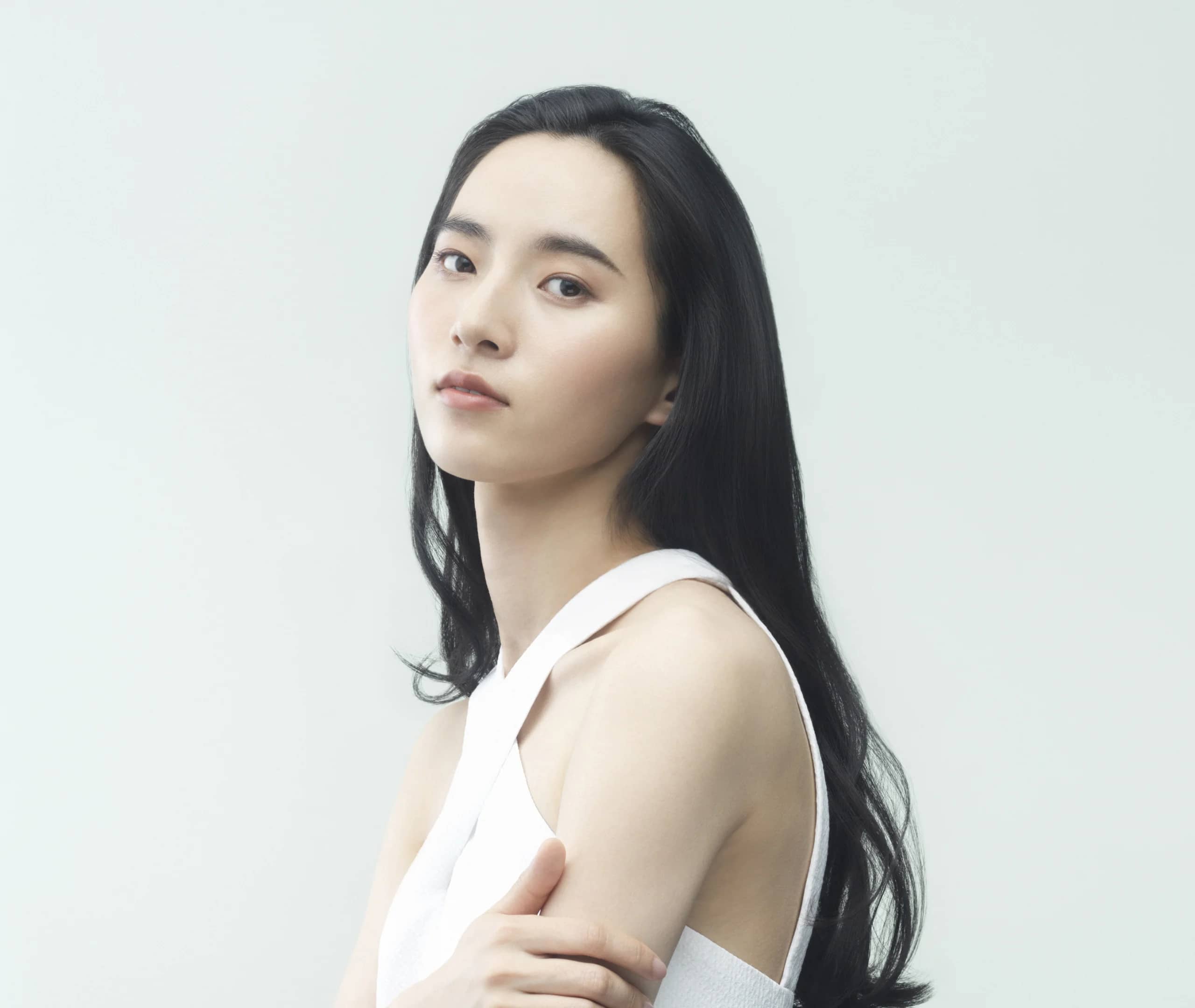 肩に手を添えて立つロングヘアの女性