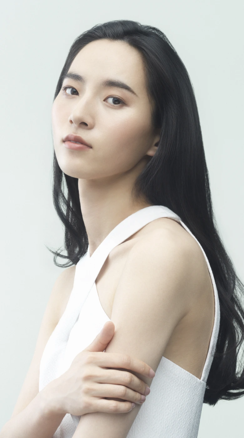 肩に手を添えて立つロングヘアの女性